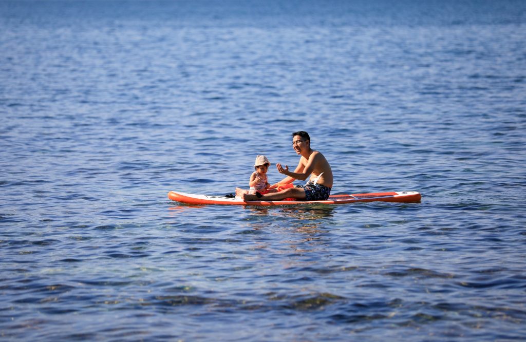 On Son Cha Island, vibrant boats sway gently in the crystal-clear waters while visitors enjoy stand-up paddleboarding (SUP) under the warm sun. The picturesque scenery is framed by lush green hills and the sparkling ocean, creating a perfect backdrop for a day of adventure and relaxation. Enthusiastic paddlers glide across the waves, soaking in the beauty of their surroundings, while the serene atmosphere invites everyone to connect with nature. Whether you're a seasoned SUP enthusiast or a beginner, the calm waters of Son Cha Island make it an ideal spot for enjoying this fun water activity.