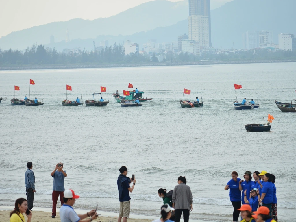In the vibrant atmosphere of the Cau Ngu Festival in Thanh Khe, Da Nang, a large ceremonial boat serves as a focal point for visitors. Tourists gather around the majestic vessel, excitedly participating in the festivities. The scene is filled with colorful decorations and traditional music, reflecting the cultural significance of the festival. Locals and travelers alike come together to honor the sea gods, creating a sense of community and shared reverence for the ocean's gifts. This lively celebration showcases the beauty of maritime traditions while inviting everyone to experience the spirit of Da Nang.
