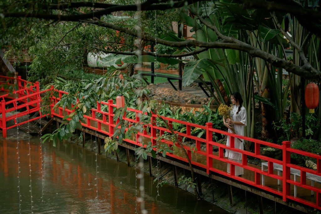 Tam Tang Bridge at Nam Son Pagoda, featuring a curved design surrounded by lush greenery