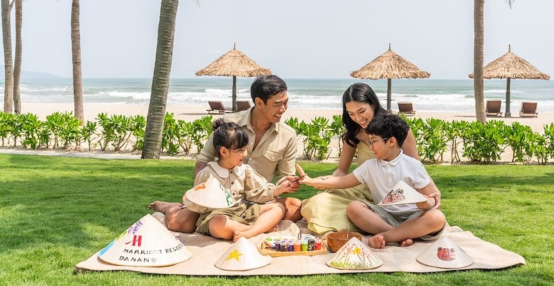 "A joyful family enjoying playful moments together at Furama Resort Da Nang, engaging in outdoor activities under the sun with smiles and laughter, symbolizing relaxation and connection in a luxurious resort setting