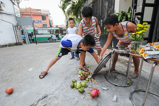 A group of children is playfully engaging in traditional ghost-catching games during the lunar month of July in Vietnam