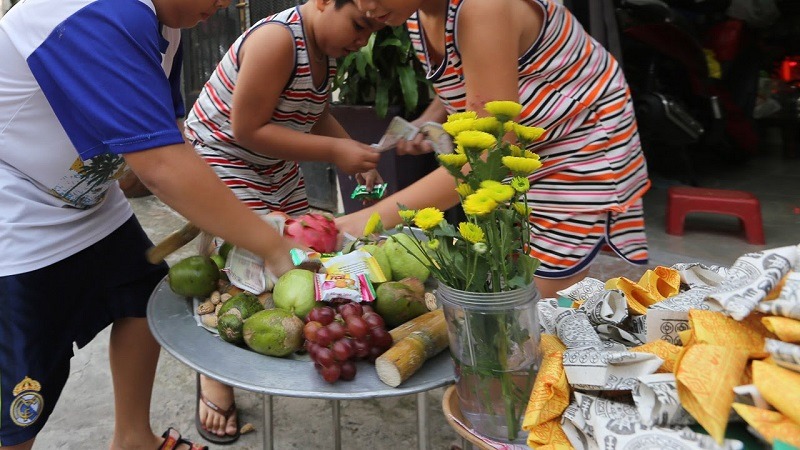 A group of children is playfully engaging in traditional ghost-catching games during the lunar month of July in Vietnam