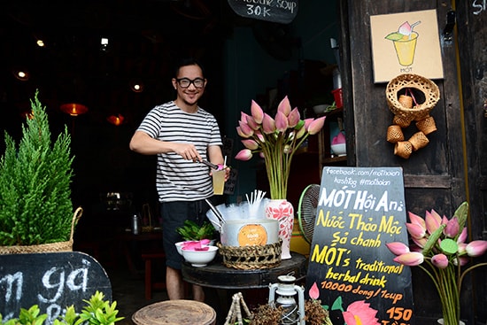 The creator of Nước Mót serves the herbal tea into a cup at their shop in Hoi An.