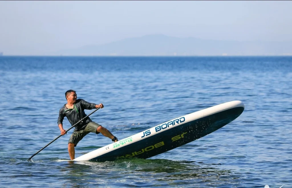 On Son Cha Island, vibrant boats sway gently in the crystal-clear waters while visitors enjoy stand-up paddleboarding (SUP) under the warm sun. The picturesque scenery is framed by lush green hills and the sparkling ocean, creating a perfect backdrop for a day of adventure and relaxation. Enthusiastic paddlers glide across the waves, soaking in the beauty of their surroundings, while the serene atmosphere invites everyone to connect with nature. Whether you're a seasoned SUP enthusiast or a beginner, the calm waters of Son Cha Island make it an ideal spot for enjoying this fun water activity.