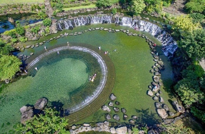 A panoramic view of Suoi Mo with its clear water flowing over large rocks.
