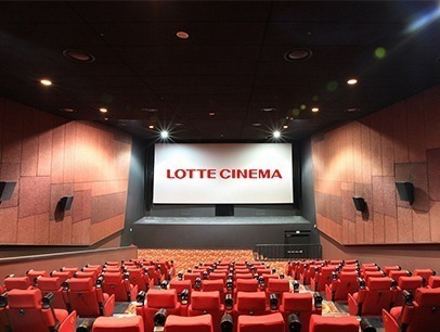 A cinema interior featuring red seats arranged in rows facing a large screen, creating an inviting atmosphere for moviegoers.