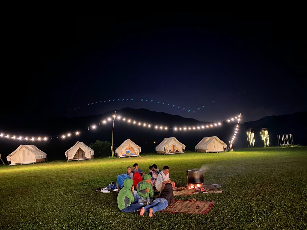 A family gathered around a cozy campfire at Yen Retreat during the evening, sharing stories and laughter under a starry sky, creating unforgettable memories together.