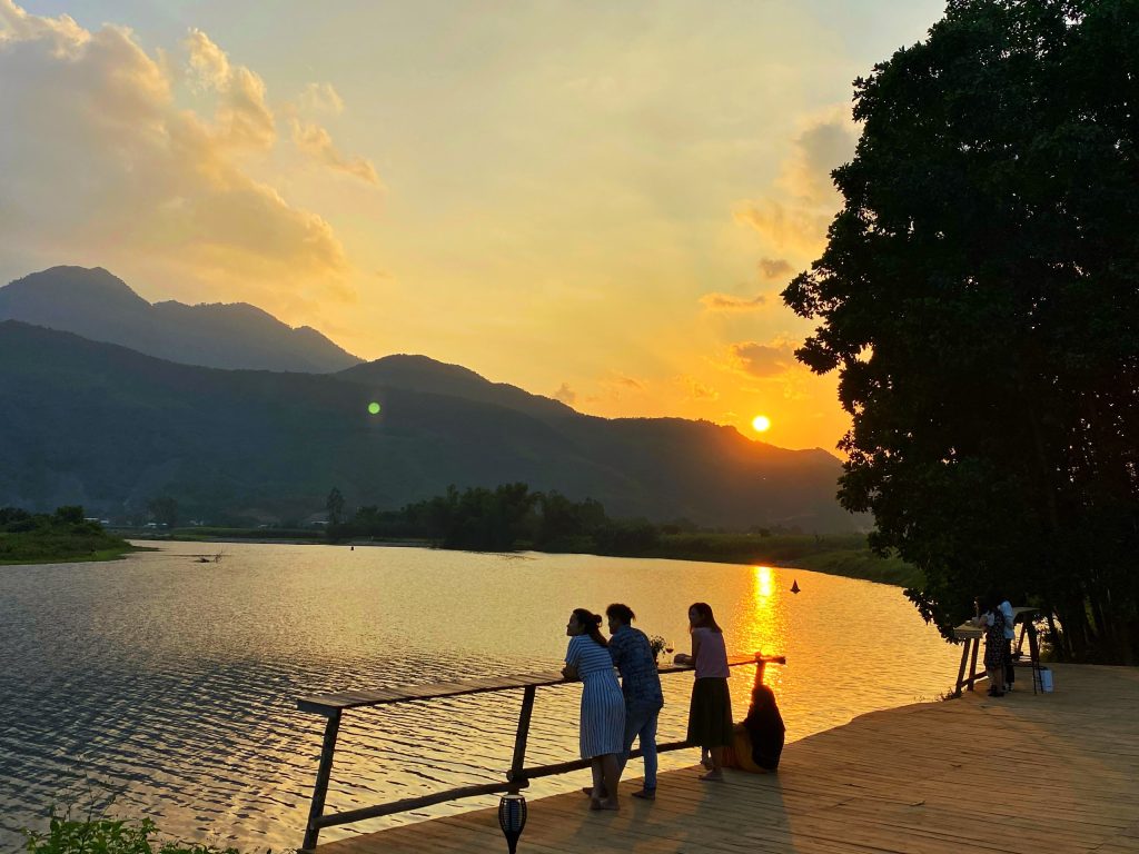A serene sunrise at Yen Retreat, casting golden light over the peaceful Cu De River