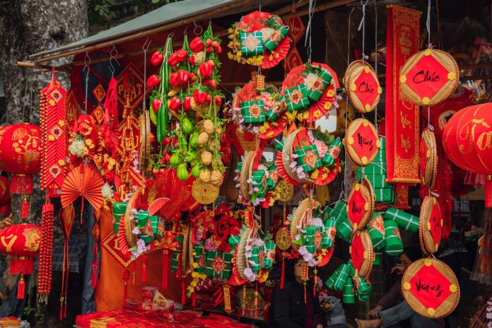 Colorful Chinese New Year decorations displayed for sale at a bustling market, celebrating the Tet holiday festivities.