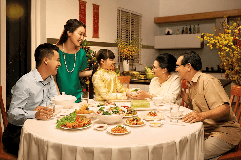 A family gathered around a table, enjoying a festive meal together during the Tet holiday celebration